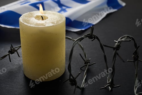 Vista previa: Flag of Israel, barbed wire and burning candle on black background. Holocaust memory day