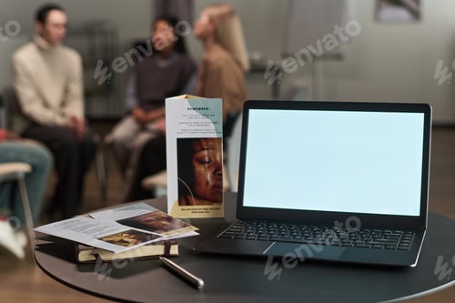 Preview: Laptop on Table with Brochures during Multiethnic Group Therapy Session