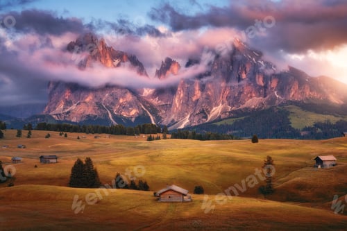 Preview: Wooden houses on orange meadows in mountain valley in autumn