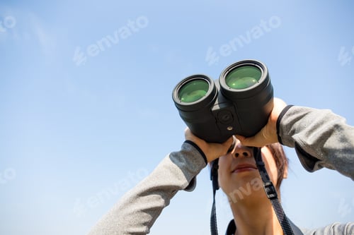 Preview: Woman watching though binoculars