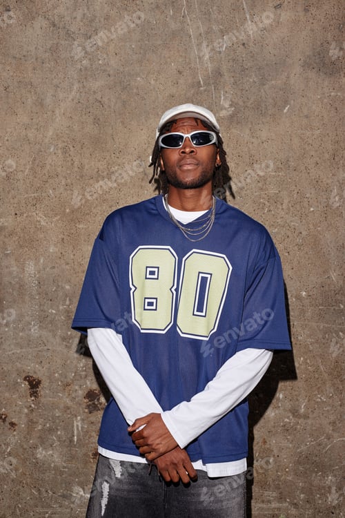 Preview: Portrait of Young Adult Black Man Wearing Sunglasses Standing Against Wall