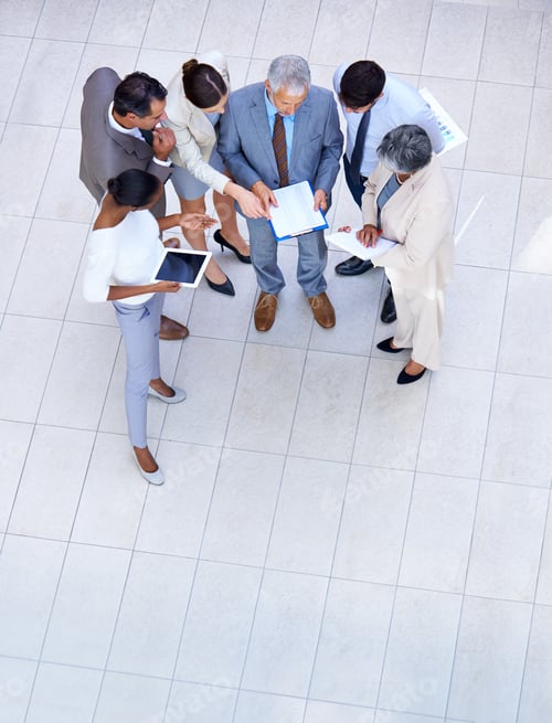 Preview: Full length shot of a group of businesspeople discussing paperwork