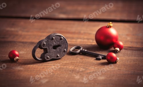 Preview: Vintage lock and key with Christmas baubles on wooden table
