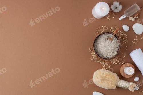 Preview: Spa treatment with cosmetic bottle, candles and towel on brown background. Flat lay, copy space.