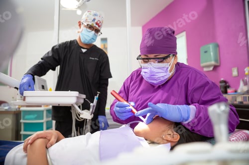 Preview: Mexican female dentist doing dental treatment on a young girl while the male assistant is watching