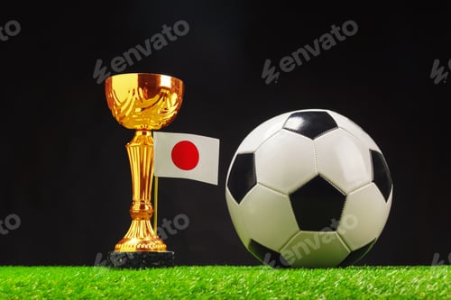 Preview: Soccer trophy with Japan flag and a football on grass background during a sports event