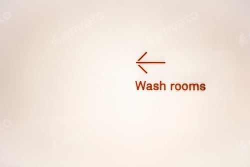 Preview: Wash rooms sigh and arrow on a white wall