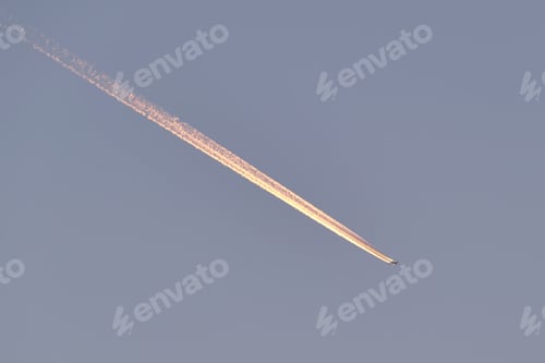 Preview: Distant passenger jet plane flying on high altitude on clear blue sky leaving white smoke trace of