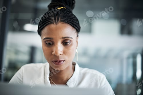 Preview: Shot of an attractive young businesswoman sitting alone in her office and using her laptop