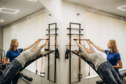 Preview: a rehabilitator works out with an older woman in the gym