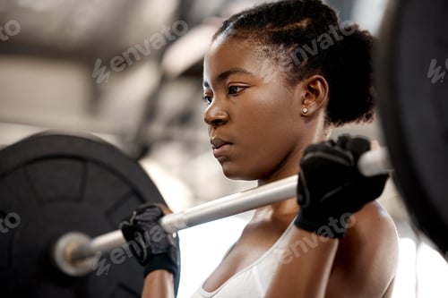 Preview: You cant fake strong. Shot of a sporty young woman exercising with a barbell in a gym.