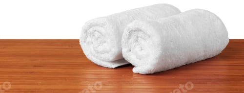 Preview: Soft white towels are neatly placed on a wooden table in a simple setting