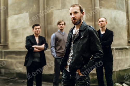 Preview: stylish handsome group of men standing and posing on the background of city street