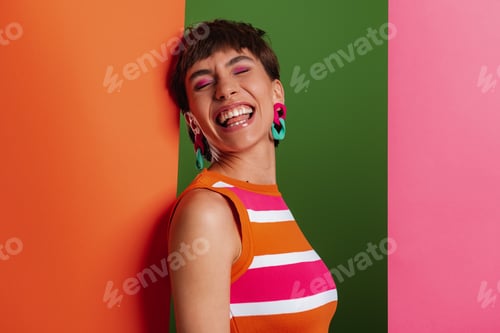 Preview: Attractive young woman looking excited while standing between colorful banners