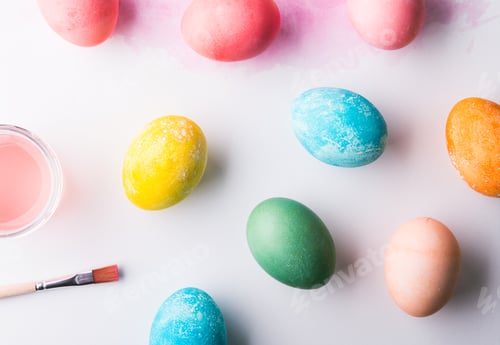 Preview: Painted eggs flat lay on a white background. Easter and spring composition. Copy space.