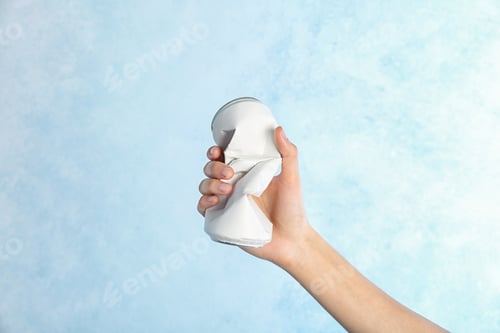 Preview: Woman holding crumpled aluminum can on color background. Metal waste recycling