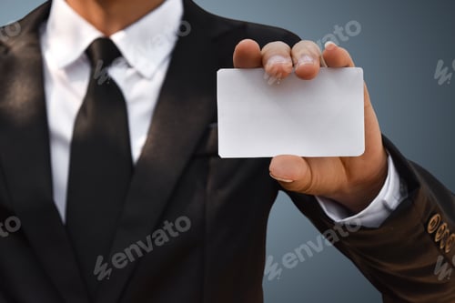 Preview: Closeup of businessman showing white piece of paper in black suit