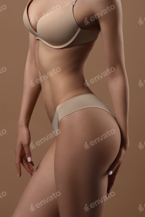 Preview: Thin young woman in underwear on beige background