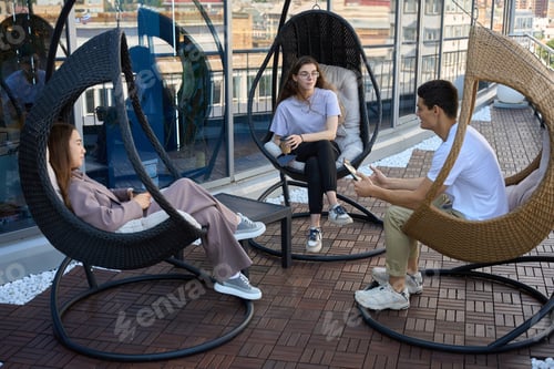 Preview: Man and two women sitting on terrace of business center