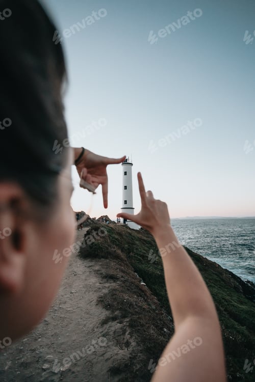 Preview: Traveler with backpack relaxing by coast at sunset. Young woman breathing deep feeling happy