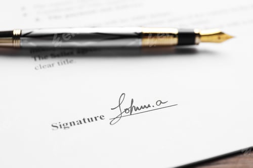 Preview: Fountain pen and signature on contract at wooden table, closeup