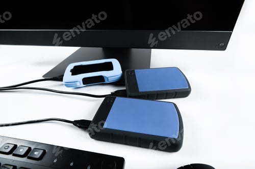 Preview: Multiple external hard drives connected to a monoblock on a white background.Computer with hard
