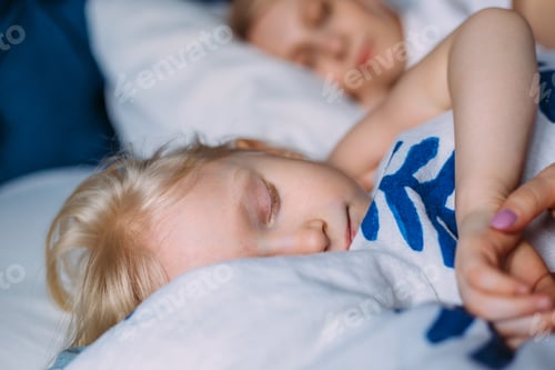 Preview: Cute little girl sleeping with mother in bed. Interior. Concept care