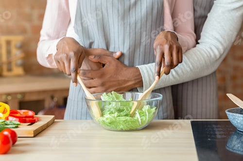 Preview: Cropped image of married couple cooking together at kitchen