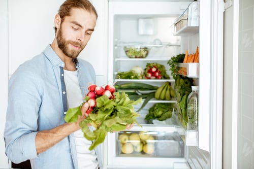 Preview: Man with fresh vegetables at the kitchen