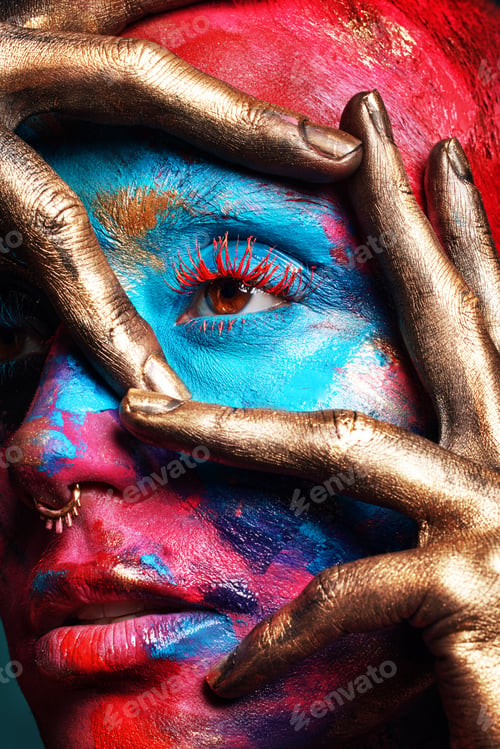 Preview: Shot of an attractive young woman posing alone in the studio with paint on her face