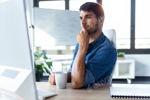 Preview: Software developer thinking in new project while working with computer in the modern startup office.