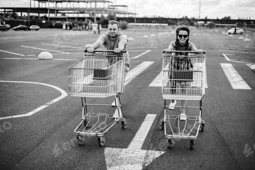 Preview: Supermarket Trolley. A Man And A Woman Are Driving A Supermarket Trolley.