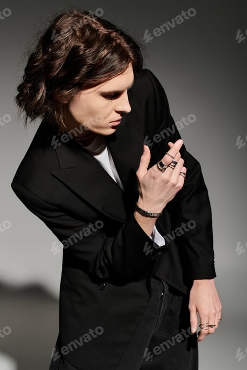 Preview: Handsome young man poses in a striking black suit, demonstrating unique style and confidence.