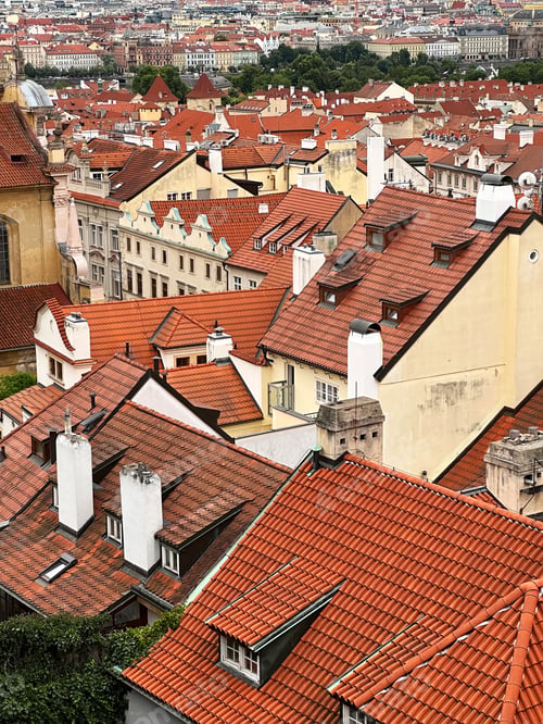 Preview: Abstract Geometric Pattern From Roofs of Old Town With Orange Colored Shingle With Chimneys, Trees