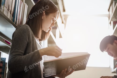 Preview: A female college student with a male close friend sitting in the university library reading