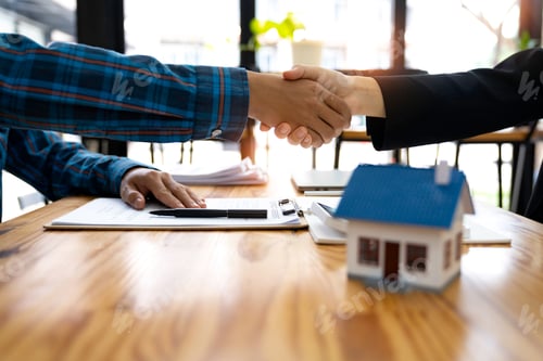 Preview: Real estate agents and customers shake hands together celebrating a finished contract after about ho