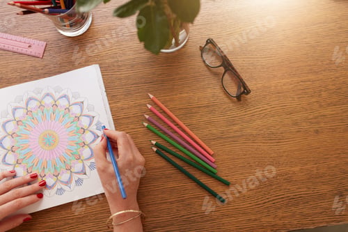 Preview: Female hands drawing in adult colouring book