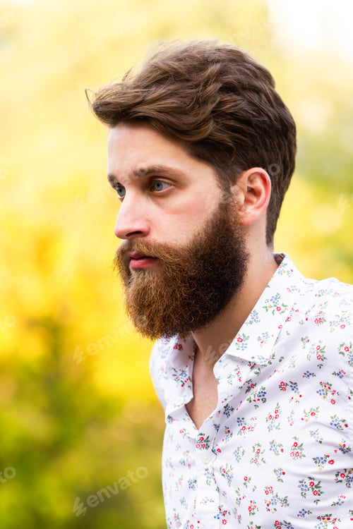 Preview: A man portrait with blue eyes and a beard. Autumn background