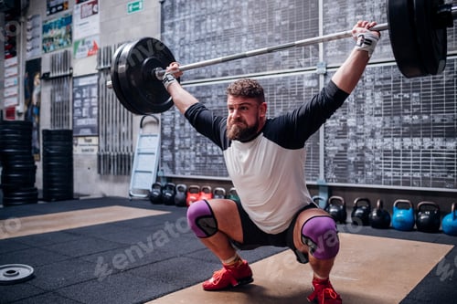 Preview: Young man lifting barbell in gym