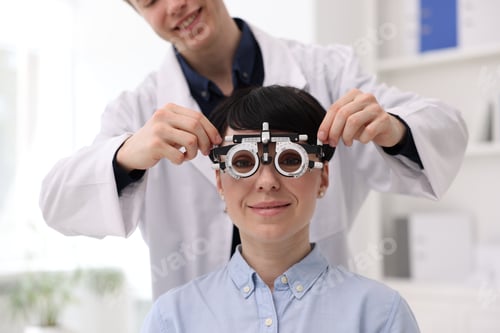 Preview: Ophthalmologist examining patient's vision with trial frame in clinic, closeup