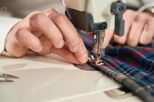 Preview: Experienced tailor is threading sewing machine before work