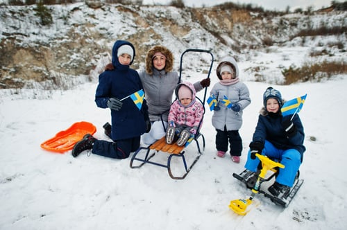 Preview: Scandinavian family with Sweden flag in winter swedish landscape.
