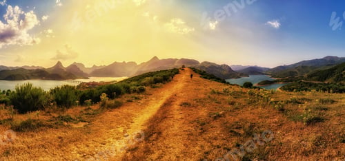 Preview: Panoramic shot of beautiful hills and the sea under the sunset
