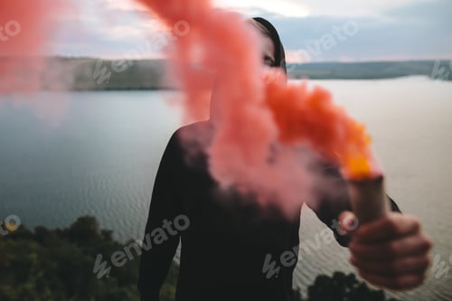 Preview: Ultras hooligan holding red smoke bomb in hand with amazing view on river