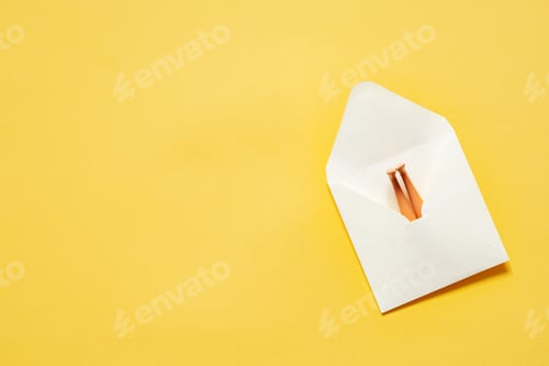 Preview: White paper envelope with doll legs sticking out on yellow background