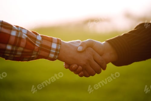 Preview: Handshake two farmer on background of wheat field at sunset. The concept of agricultural business.
