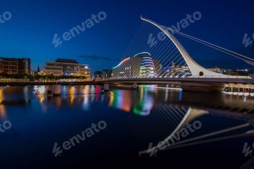 Preview: a bridge that is over the water at night time and with lights reflecting in it