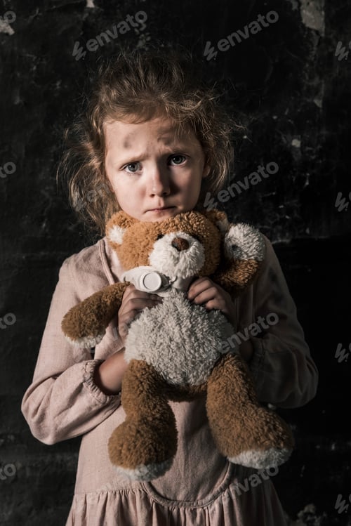 Preview: frustrated kid holding teddy bear in dirty room, post apocalyptic concept