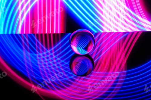 Preview: Crystal ball on a reflective surface with colorful neon lighting behind