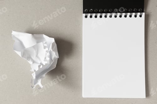 Preview: Open notebook with blank white paper sheet and crumpled paper ball. Concept stress, mistakes